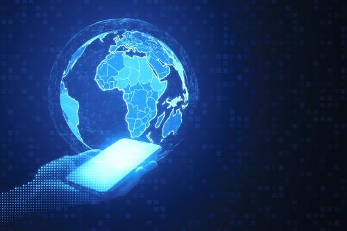 Close up of pixel hands holding mobile phone with digital polygonal globes on blue background. Global network and innovation