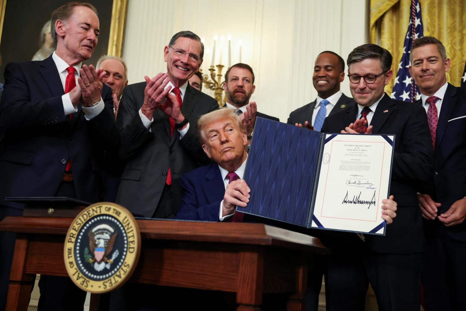 U.S. President Donald Trump shows a signed resolution approved by Congress to rescind the EPA's 2023 approval of California's plans to require a rising number of zero-emission heavy-duty trucks, and another resolution on California's low-NOx, or low-nitrogen oxide, regulation for heavy-duty highway and off-road vehicles and engines, at the White House in Washington, D.C., U.S., June 12, 2025. REUTERS/Evelyn Hockstein